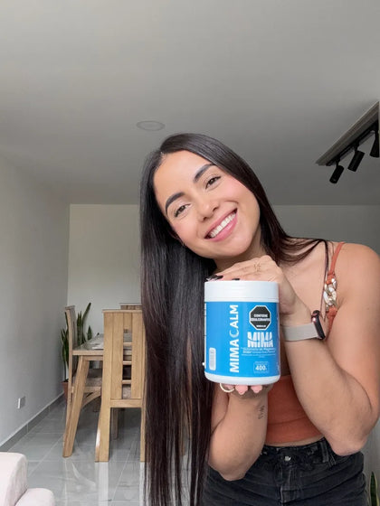 Camila sonriendo con su frasco de MIMACALM en casa