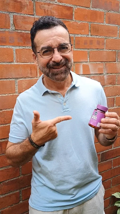 Carlos Mauricio sonriendo y señalando su frasco de MIMANAD