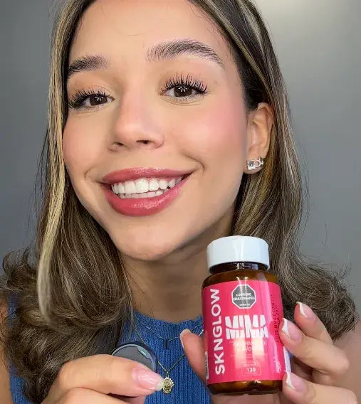 Clienta de MIMA sonriendo con su frasco de Sknglow entre las manos