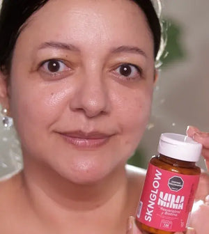 Clienta sonriendo con su frasco de Sknglow junto al rostro