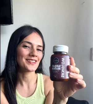 Clienta sonriendo muestra a cámara su frasco de Sknglow