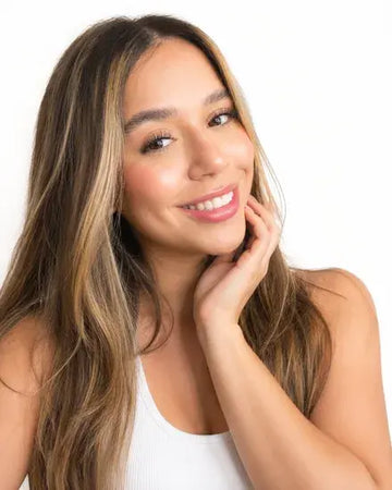 Mujer sonriendo con la mano en el pecho